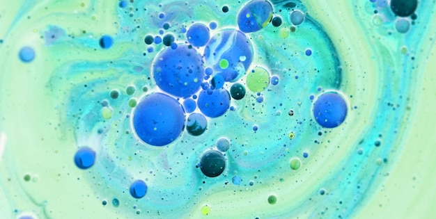 Uma pintura colorida com bolhas azuis e verdes no centro.