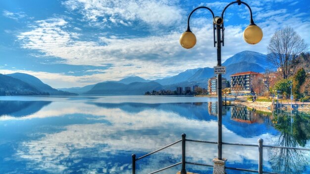 uma pintura de um lago com uma lâmpada e um poste de lâmpada