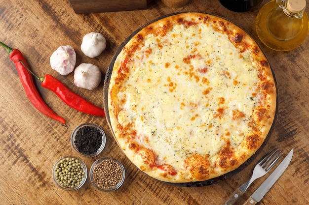 Uma pizza com queijo e outros ingredientes sobre uma mesa.