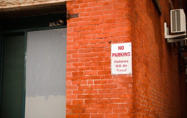 Uma placa em uma parede de tijolos diz que não há estacionamento.