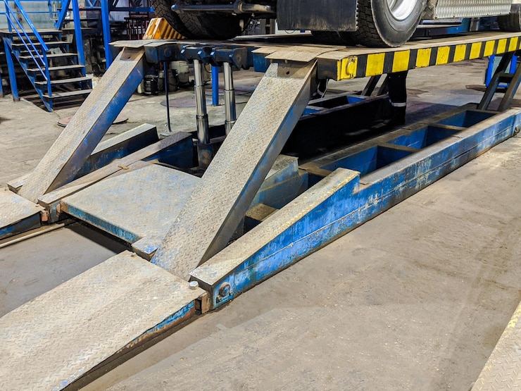 Foto uma plataforma hidráulica para empilhador de carga levantar o carro na plataforma fechar