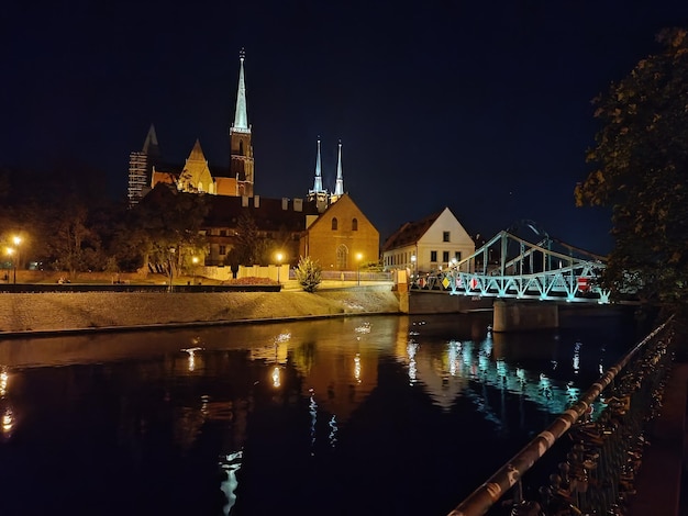 Uma ponte sobre um rio com uma igreja ao fundo.