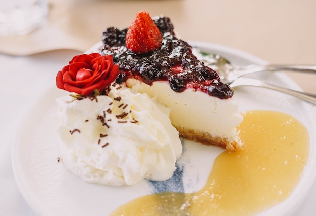 Uma porção de cheesecake com frutas vermelhas e creme