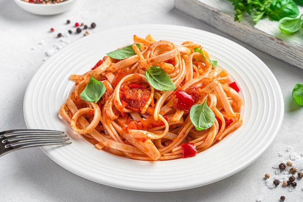 Uma porção de macarrão com molho de tomate em um fundo claro comida vegetariana