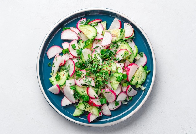 Uma porção de salada de legumes com pepino rabanete e ervas em um fundo cinza Vista superior fechada