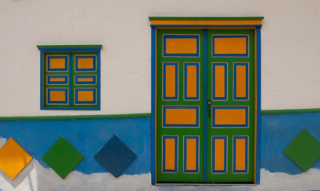 Foto uma porta colorida com tons de verde, azul e amarelo em uma aldeia colombiana