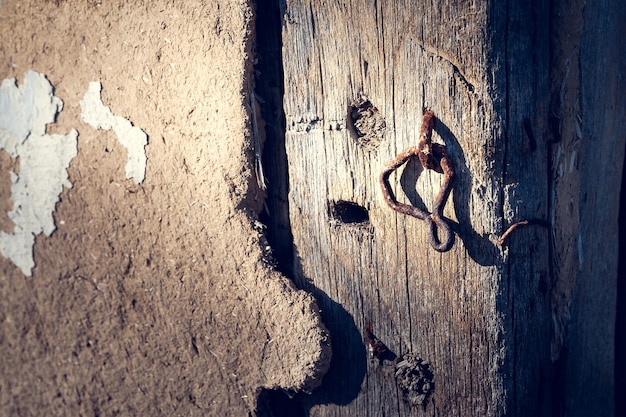 Uma porta de madeira com um gancho enferrujado