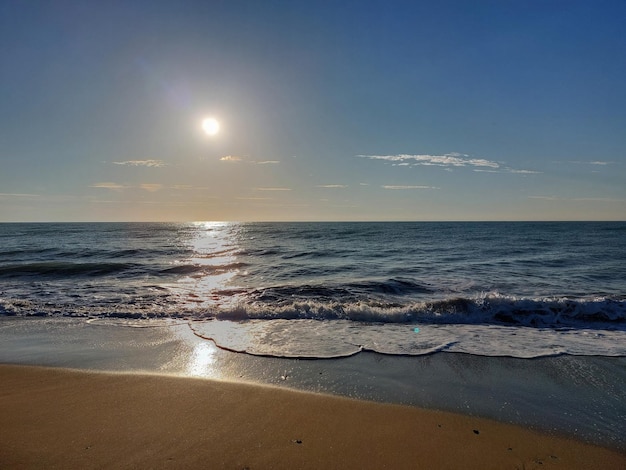 Uma praia com o sol brilhando sobre ela