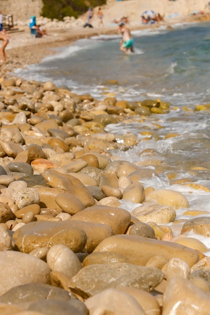 Uma praia com pedras e ondas na água