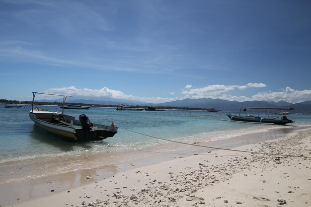 Uma praia com um barco e montanhas ao fundo