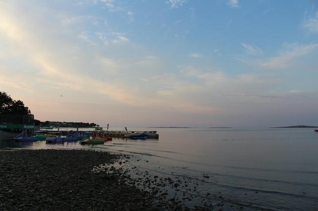 Uma praia com um barco e um pôr do sol ao fundo