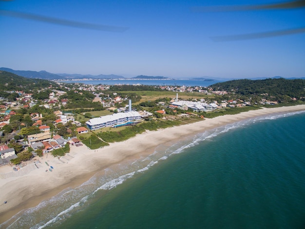 Uma praia com um prédio e o mar ao fundo