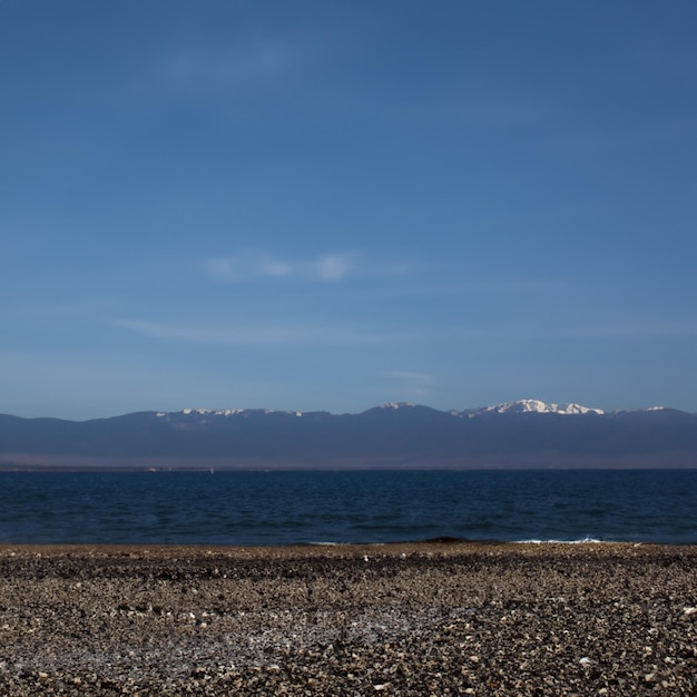 Foto uma praia rochosa com montanhas ao fundo