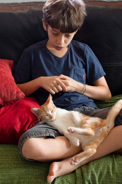 Foto uma pré-adolescente brinca com seu querido gatinho que está em seu colo a criança acaricia o bichinho crianças e gatos