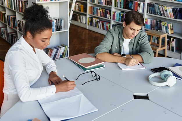 Uma professora dedicada guia seu jovem aluno na aprendizagem focada na biblioteca