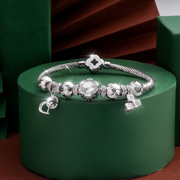 Uma pulseira de prata com um pingente de diamante fica em uma caixa verde.