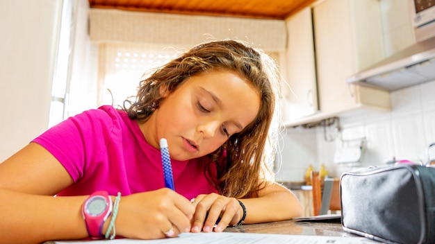 Foto uma rapariga a escrever num pedaço de papel.
