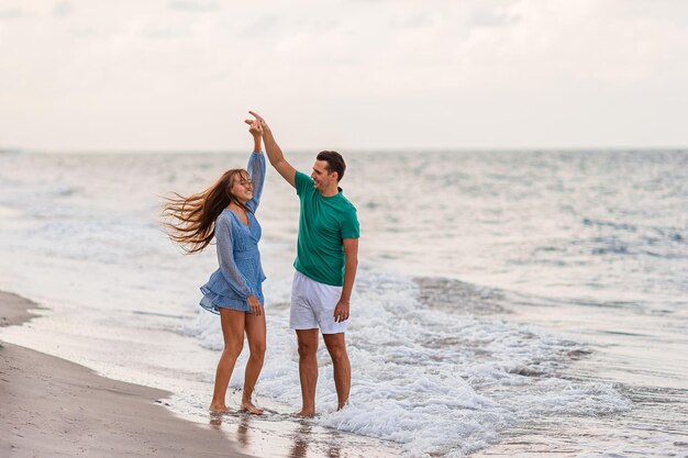 Foto uma rapariga adorável e um pai feliz a divertir-se nas férias na praia.