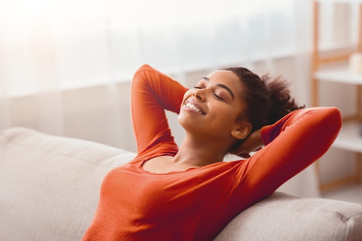 Foto uma rapariga afro feliz a relaxar no sofá em casa.