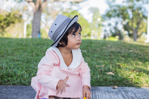 Foto uma rapariga bonita a olhar para outro lado enquanto está sentada no parque.
