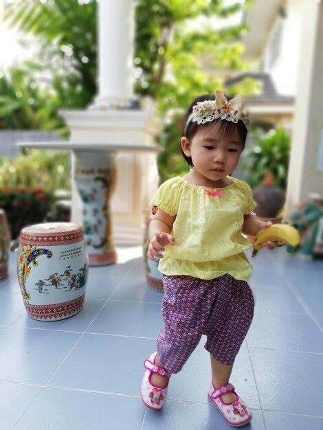 Foto uma rapariga bonita de pé no chão de azulejos