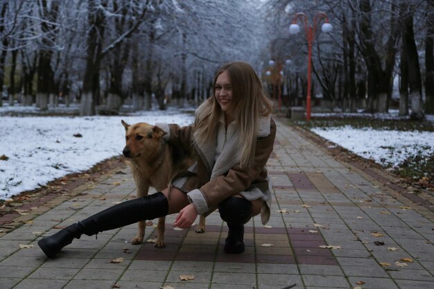 Uma rapariga com um cão no chão e uma mulher com um frisbee