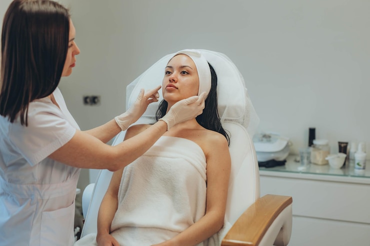 Foto uma rapariga num consultório de cosmetologistas a limpar a pele.