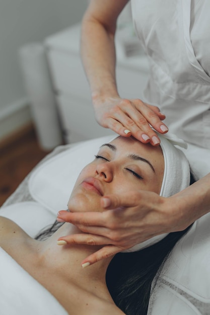 Uma rapariga num consultório de cosmetologistas a limpar a pele.