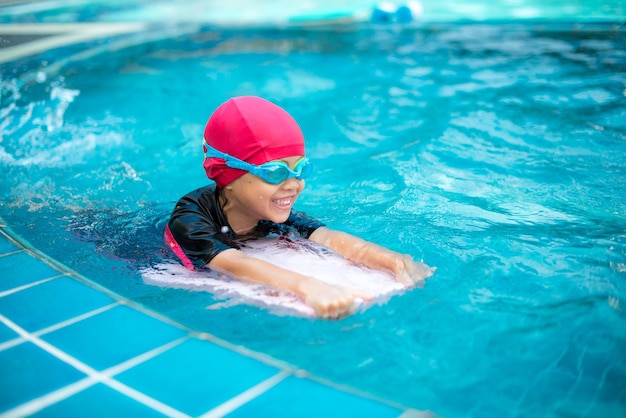 Uma rapariga sorridente a nadar na piscina.