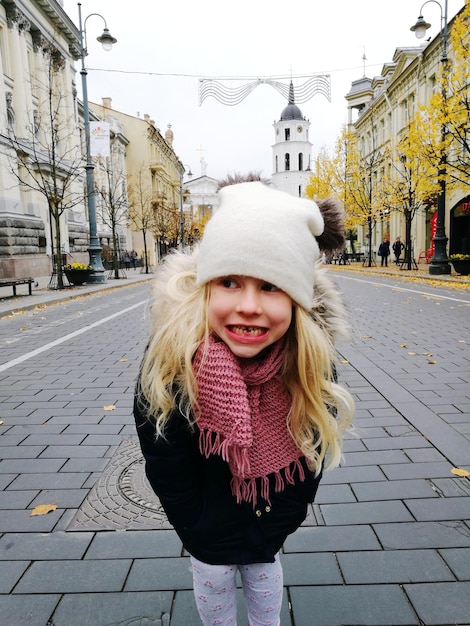 Uma rapariga sorridente de pé na rua da cidade