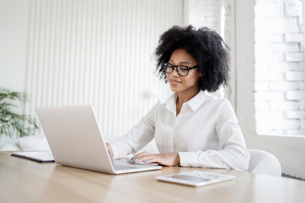 Uma recepcionista feminina em roupas de negócios trabalha no escritório responde ao correio do cliente um laptop