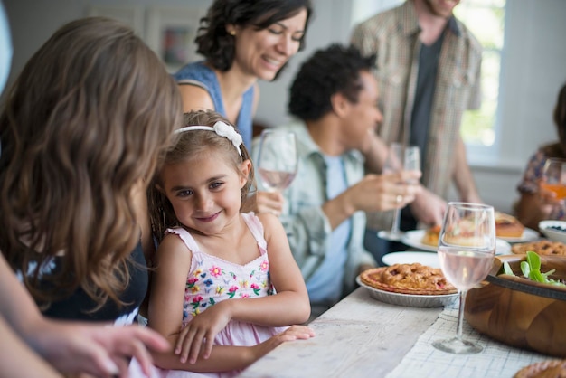 Uma reunião de família para uma refeição Adultos e crianças à volta de uma mesa