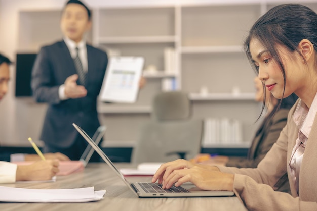 Uma reunião de negócios está ocorrendo no escritório e uma apresentação de negócios está sendo feita em um laptop