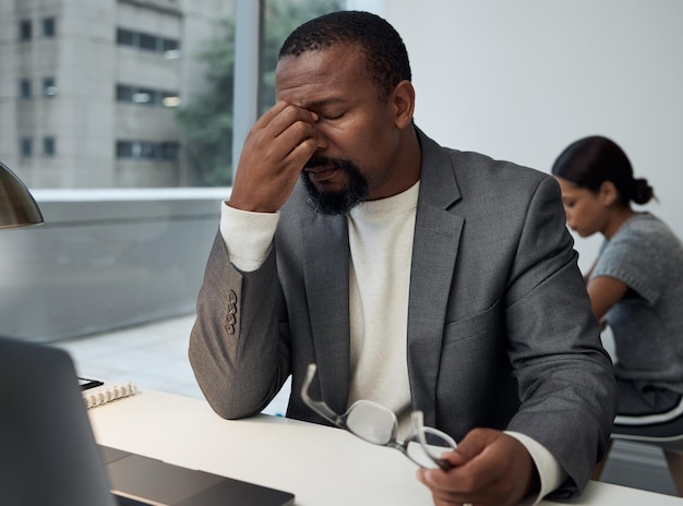 Uma reunião realmente não é o que eu quero agora Foto de um jovem empresário com dor de cabeça no trabalho