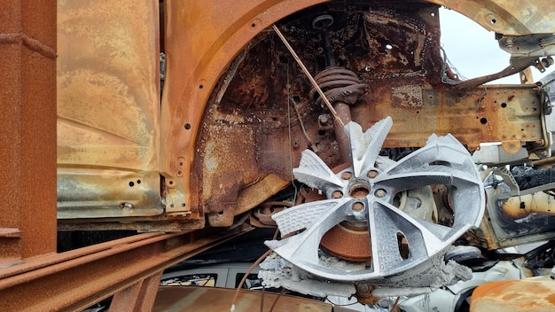 Foto uma roda enferrujada de um carro que tem uma placa de metal que diz 'ferrugem' nela.