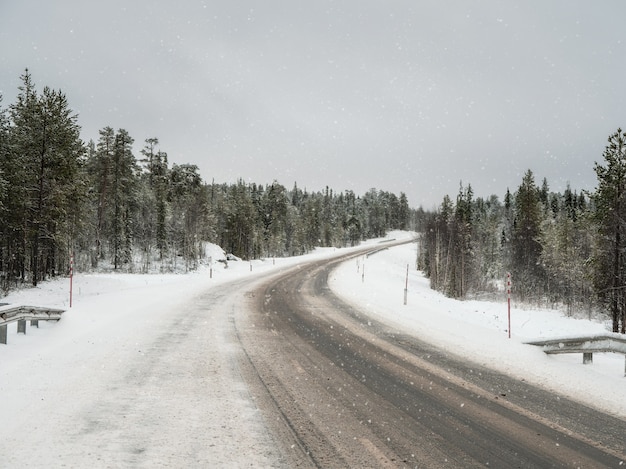 Uma rodovia de inverno vazia e suja. Uma curva à direita em uma estrada escorregadia de inverno.