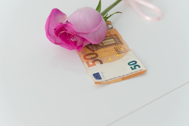 Uma rosa como presente com uma nota de euro