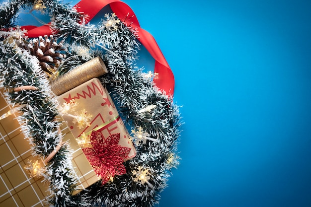 Uma sacola de compras dourada com presentes de natal e enfeites em um fundo azul. copie o espaço