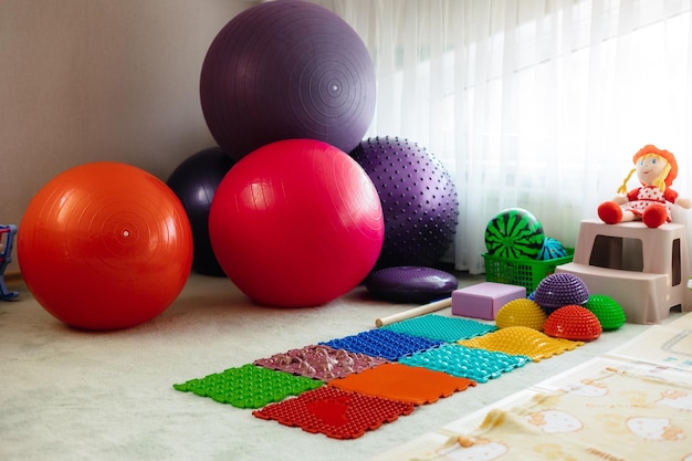 Uma sala com bolas coloridas e um tapete que diz 'pilates'