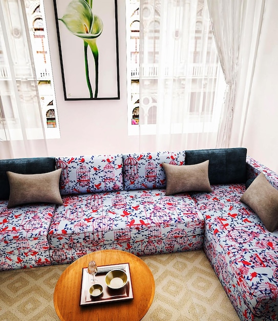 Uma sala de estar com um sofá e uma foto de uma flor na parede.