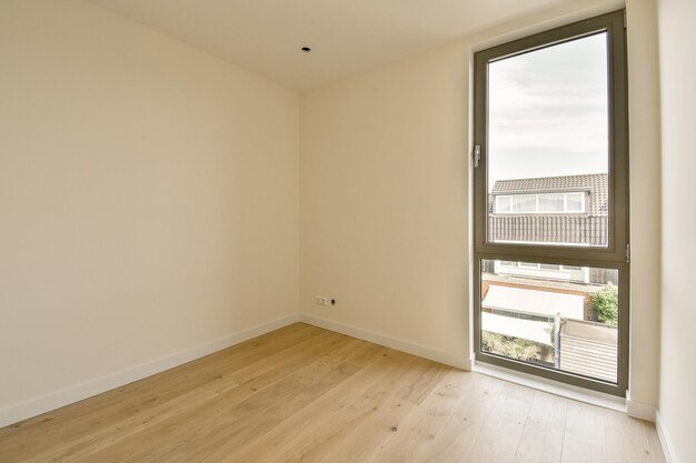 uma sala de estar com uma grande janela e pisos de madeira