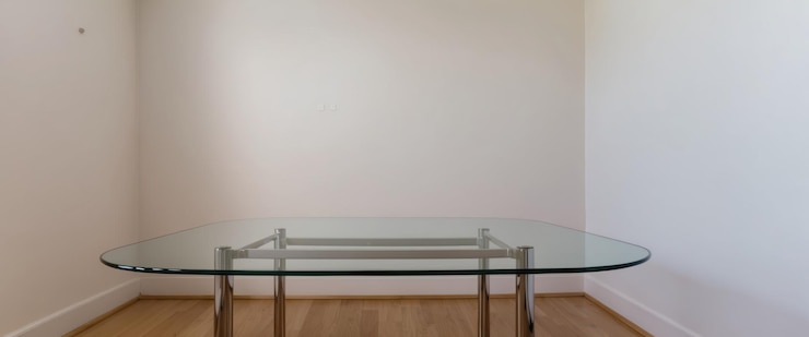 Foto uma sala de jantar sem móveis com uma mesa de vidro minimalista e paredes leves