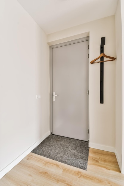Foto uma sala vazia com paredes brancas e piso de madeira a porta está aberta no lado direito da sala
