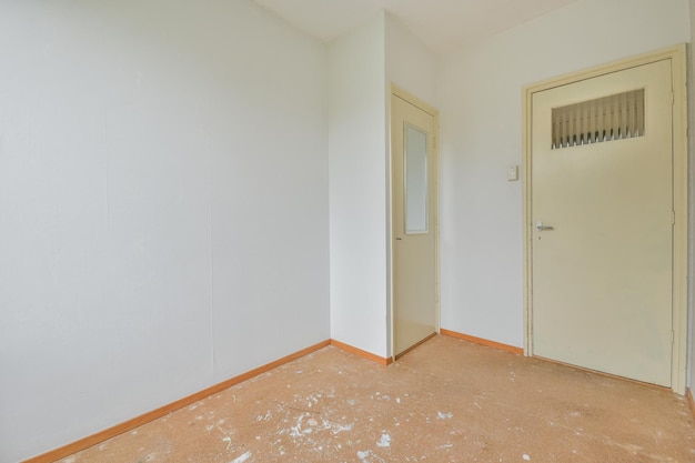 Foto uma sala vazia com portas brancas a precisar de reparação