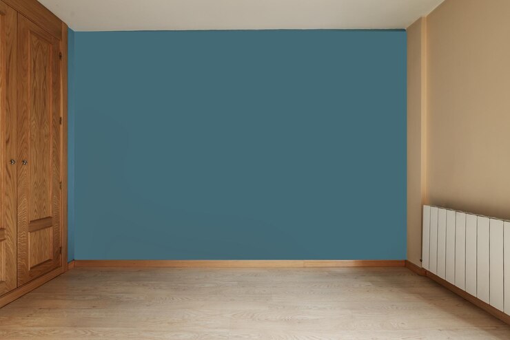 Foto uma sala vazia com um guarda-roupa embutido cobrindo uma parede com portas de madeira com teto de chão, uma parede pintada de azul e um radiador de alumínio branco