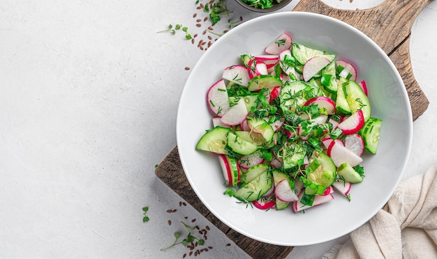 Uma salada saudável com rabanetes e ervas em um fundo claro com espaço para copiar