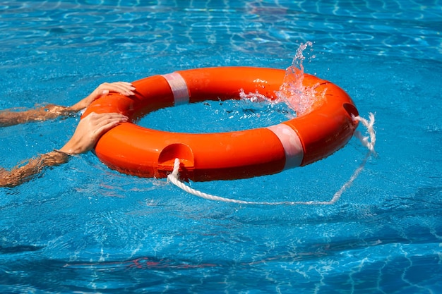 Uma salva-vidas a treinar com um colete salva-vidos a nadar na piscina.