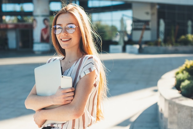 Uma senhora alegre com um sorriso atraente que está caminhando e aproveitando o tempo livre ao sol.