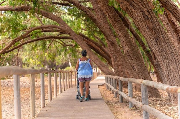 Uma senhora idosa caminhando no caminho do parque natural lagunas de la mata em torrevieja alicante