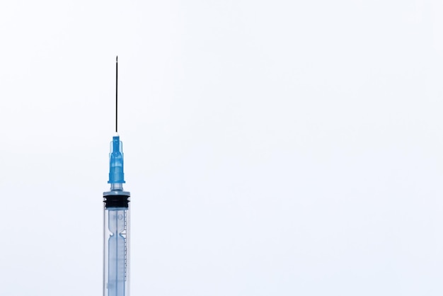 Foto uma seringa de injeção plástica descartável aberta, totalmente visível contra um fundo branco